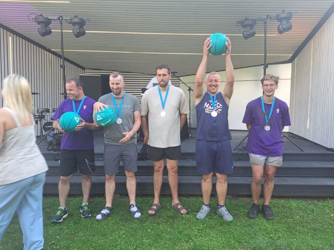 Sporta spēļu dalībnieki ar medaļām uz estrādes skatuves